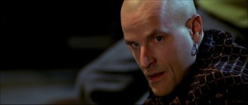Movie still from “Face/Off” (1997), directed by John Woo – A man with bald head looking into the camera; Close Up shot, Low angle