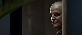 Movie still from “Face/Off” (1997), directed by John Woo – A man with a bald head is posing for a picture; Close Up shot, Low angle