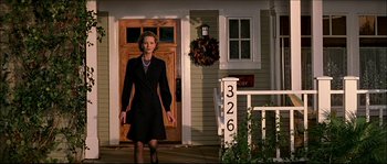 Movie still from “Face/Off” (1997), directed by John Woo – A woman standing in front of a door way; Medium shot, Low angle
