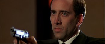 Movie still from “Face/Off” (1997), directed by John Woo – A person wearing a suit and tie; Close Up shot, Over the shoulder angle