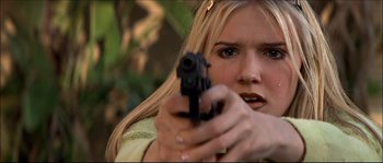 Movie still from “Face/Off” (1997), directed by John Woo – A woman holding a gun in her hand; Close Up shot, Low angle