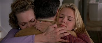 Movie still from “Face/Off” (1997), directed by John Woo – Two women and a man hugging each other; Close Up shot, Over the shoulder angle