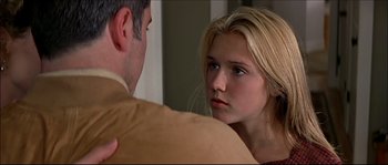 Movie still from “Face/Off” (1997), directed by John Woo – A young woman looking at a man in a room; Close Up shot, Over the shoulder angle
