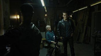 Movie still from “Fahrenheit 451” (2018), directed by Ramin Bahrani – A man in a leather jacket standing next to another man in a leather jacket; Wide shot, High angle