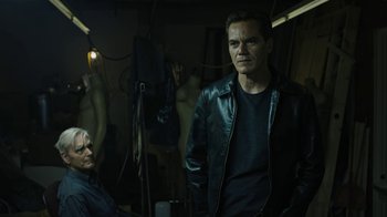 Movie still from “Fahrenheit 451” (2018), directed by Ramin Bahrani – A man wearing a leather jacket standing next to a woman; Medium shot, Low angle