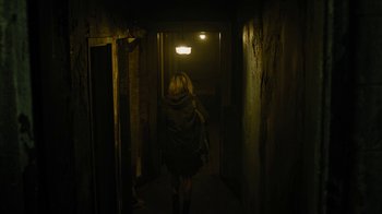 Movie still from “Fahrenheit 451” (2018), directed by Ramin Bahrani – A woman walking down a hallway in a dark building; Wide shot, High angle