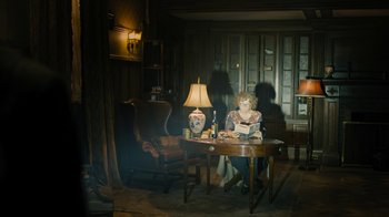 Movie still from “Fahrenheit 451” (2018), directed by Ramin Bahrani – A woman sitting at a table reading a book; Wide shot, High angle