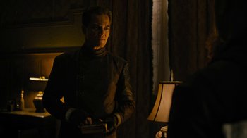 Movie still from “Fahrenheit 451” (2018), directed by Ramin Bahrani – A man standing in front of a lamp in a room; Medium shot, Over the shoulder angle