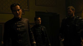 Movie still from “Fahrenheit 451” (2018), directed by Ramin Bahrani – A group of men standing next to each other in a room; Medium shot, Low angle