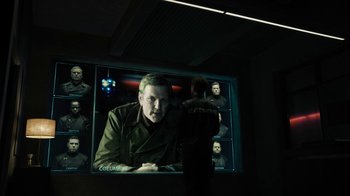 Movie still from “Fahrenheit 451” (2018), directed by Ramin Bahrani – A man in a dark room looking at a television screen; Medium shot, Over the shoulder angle