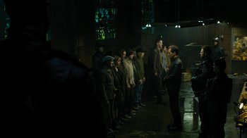 Movie still from “Fahrenheit 451” (2018), directed by Ramin Bahrani – A group of people standing in a dark room; Wide shot, High angle