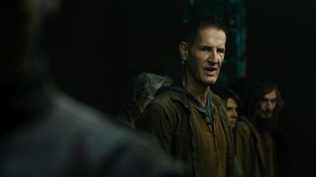 Movie still from “Fahrenheit 451” (2018), directed by Ramin Bahrani – A person standing in a dark room; Close Up shot, Over the shoulder angle