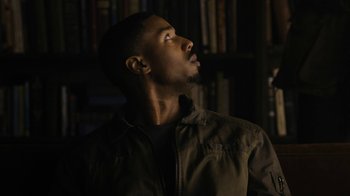 Movie still from “Fahrenheit 451” (2018), directed by Ramin Bahrani – A man looking up into the sky in front of a book shelf; Close Up shot, Low angle