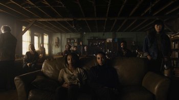 Movie still from “Fahrenheit 451” (2018), directed by Ramin Bahrani – A group of people sitting on top of couches in a living room; Wide shot, Low angle