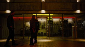 Movie still from “Fahrenheit 451” (2018), directed by Ramin Bahrani – Two men standing in front of a building at night; Wide shot, Low angle