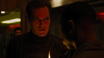 Movie still from “Fahrenheit 451” (2018), directed by Ramin Bahrani – A man is looking at another man with a candle in his hand; Close Up shot, Over the shoulder angle