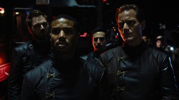 Movie still from “Fahrenheit 451” (2018), directed by Ramin Bahrani – A group of men standing next to each other in a dark room; Medium shot, Low angle