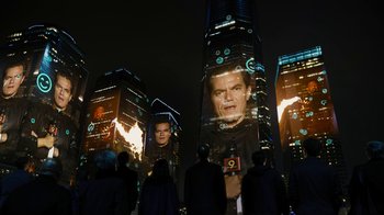 Movie still from “Fahrenheit 451” (2018), directed by Ramin Bahrani – A group of people standing in front of tall buildings at night; Medium shot, Low angle