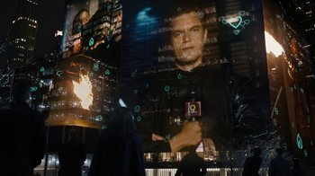 Movie still from “Fahrenheit 451” (2018), directed by Ramin Bahrani – A man holding a drink in front of an image of himself; Medium shot, Low angle