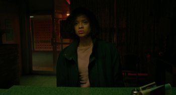 Movie still from “Fast Color” (2018), directed by Julia Hart – A woman standing in front of a table in a dark room; Medium shot, Low angle