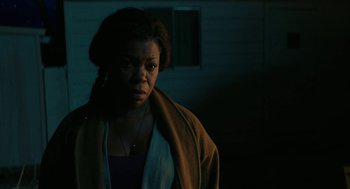 Movie still from “Fast Color” (2018), directed by Julia Hart – A woman standing in a dark room with her head turned to the side; Close Up shot, Over the shoulder angle