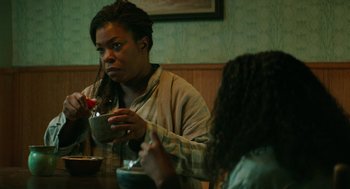 Movie still from “Fast Color” (2018), directed by Julia Hart – A woman sitting at a table with a bowl of food; Medium shot, High angle