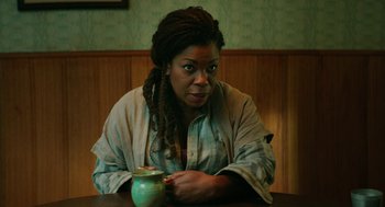 Movie still from “Fast Color” (2018), directed by Julia Hart – A woman sitting at a table with a cup of coffee; Medium shot, High angle