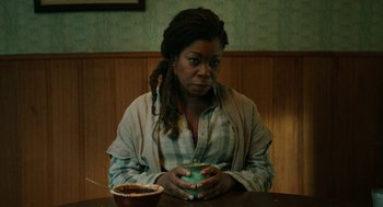 Movie still from “Fast Color” (2018), directed by Julia Hart – A woman sitting at a table with a bowl of food; Medium shot, High angle
