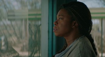Movie still from “Fast Color” (2018), directed by Julia Hart – A woman looking out of a window at the outside; Close Up shot, Low angle