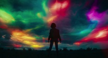 Movie still from “Fast Color” (2018), directed by Julia Hart – A person standing in front of a sky filled with colorful clouds; Extreme Wide shot, Low angle