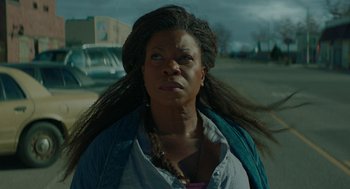 Movie still from “Fast Color” (2018), directed by Julia Hart – A woman standing on a street with her hair blowing in the wind; Close Up shot, Low angle