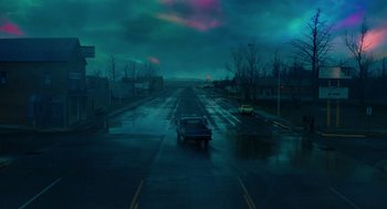 Movie still from “Fast Color” (2018), directed by Julia Hart – A car driving down a street in the rain; Extreme Wide shot, High angle