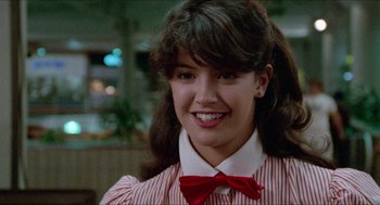 Movie still from “Fast Times at Ridgemont High” (1982), directed by Amy Heckerling – A woman with a red bow tie smiles for the camera; Close Up shot, Low angle