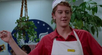 Movie still from “Fast Times at Ridgemont High” (1982), directed by Amy Heckerling – A young man wearing an apron and a hat; Close Up shot, Low angle
