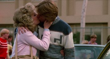 Movie still from “Fast Times at Ridgemont High” (1982), directed by Amy Heckerling – A man and a woman kissing on the street; Medium shot, Over the shoulder angle
