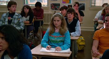 Movie still from “Fast Times at Ridgemont High” (1982), directed by Amy Heckerling – A woman sitting at a desk in front of a group of people; Medium shot, Over the shoulder angle