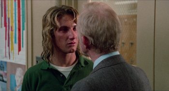 Movie still from “Fast Times at Ridgemont High” (1982), directed by Amy Heckerling – A man with long blonde hair talking to another man in a suit; Close Up shot, Over the shoulder angle