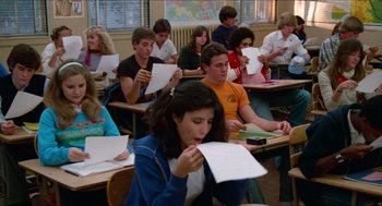 Movie still from “Fast Times at Ridgemont High” (1982), directed by Amy Heckerling – A group of people sitting in a classroom with papers in their hands; Medium shot, Low angle