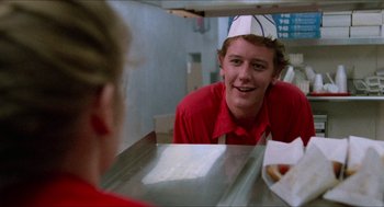 Movie still from “Fast Times at Ridgemont High” (1982), directed by Amy Heckerling – A man wearing a hat sitting at a counter; Medium shot, Low angle