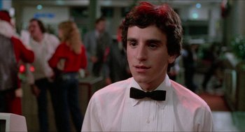 Movie still from “Fast Times at Ridgemont High” (1982), directed by Amy Heckerling – A man in a white shirt and a black bow tie; Close Up shot, Low angle