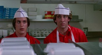 Movie still from “Fast Times at Ridgemont High” (1982), directed by Amy Heckerling – Two men wearing paper hats in a restaurant kitchen; Medium shot, Low angle