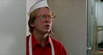 Movie still from “Fast Times at Ridgemont High” (1982), directed by Amy Heckerling – A man wearing a white hat and a red shirt; Close Up shot, Low angle