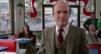Movie still from “Fast Times at Ridgemont High” (1982), directed by Amy Heckerling – A man wearing a suit and tie in a restaurant; Medium shot, Over the shoulder angle