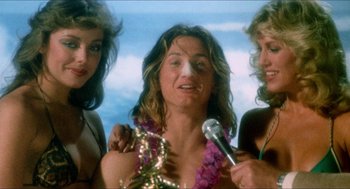 Movie still from “Fast Times at Ridgemont High” (1982), directed by Amy Heckerling – A group of women standing next to each other holding microphones; Medium shot, Low angle
