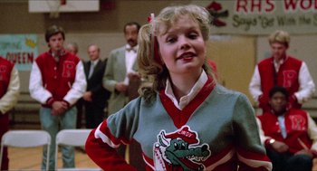 Movie still from “Fast Times at Ridgemont High” (1982), directed by Amy Heckerling – A girl in a cheerleader uniform is smiling for the camera; Close Up shot, Low angle