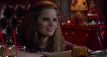 Movie still from “Fast Times at Ridgemont High” (1982), directed by Amy Heckerling – A woman sitting at a table with a box in front of her; Close Up shot, Over the shoulder angle
