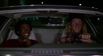 Movie still from “Fast Times at Ridgemont High” (1982), directed by Amy Heckerling – A man and a woman sitting in the back of a car; Medium shot, Low angle