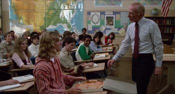 Movie still from “Fast Times at Ridgemont High” (1982), directed by Amy Heckerling – A classroom full of students sitting at desks and eating pizza; Medium shot, Over the shoulder angle