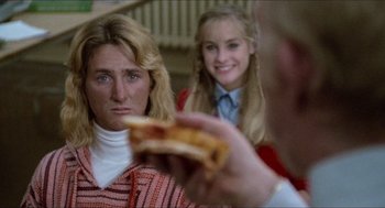 Movie still from “Fast Times at Ridgemont High” (1982), directed by Amy Heckerling – A woman sitting next to another woman while holding a piece of pizza; Close Up shot, Over the shoulder angle