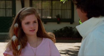 Movie still from “Fast Times at Ridgemont High” (1982), directed by Amy Heckerling – A young woman in a pink shirt is talking to a young man; Close Up shot, Over the shoulder angle